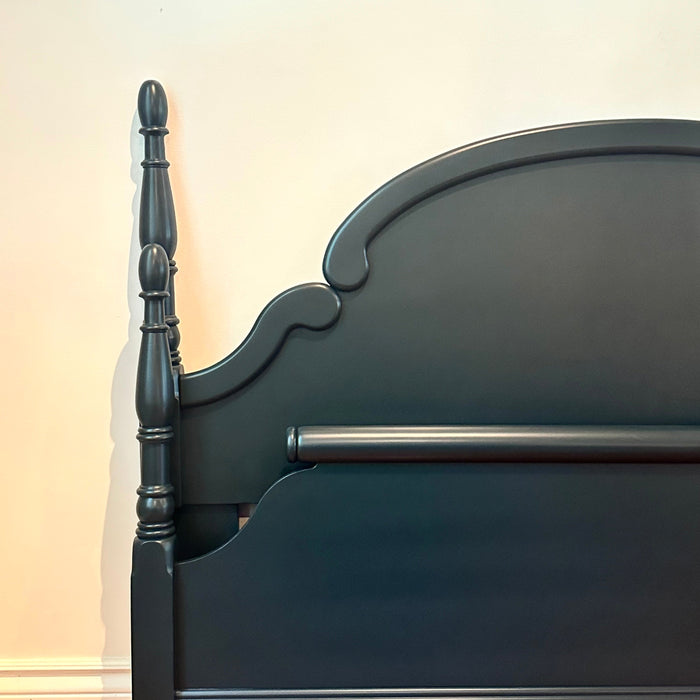 Dark Green wooden bed frame against a white wall