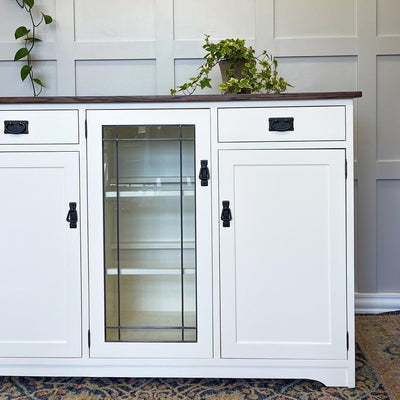 A cream coloured buffet with a dark walnut stained wood top refinished by ARK Furniture Toronto a sustainable designer furniture store from Toronto, Canada. 