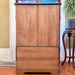 Wooden armoire in a room with a window and plant