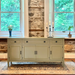 Light green sideboard against a stone wall with two windows